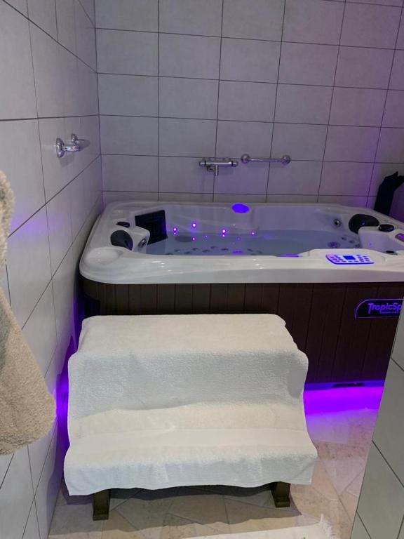 La salle de bains est pourvue d'une baignoire et de serviettes. dans l'établissement appartement avec Jacuzzi hammam sauna privatisé au rez de chaussée ds maison à Voglans à 2 kilomètres du lac du bourget en Savoie entre Chambéry et Aix les Bains cure thermale, à Voglans