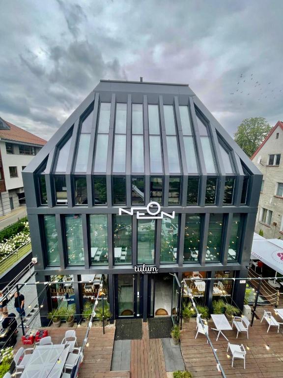 a large glass building with a sign in front of it at NEON APARTMENTS in Sopot