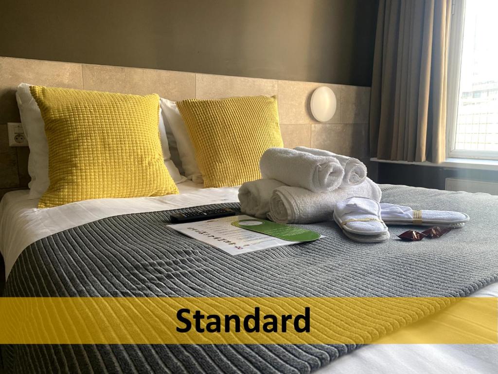 a bed with towels and shoes on top of it at Grand Hotel Central in Rotterdam