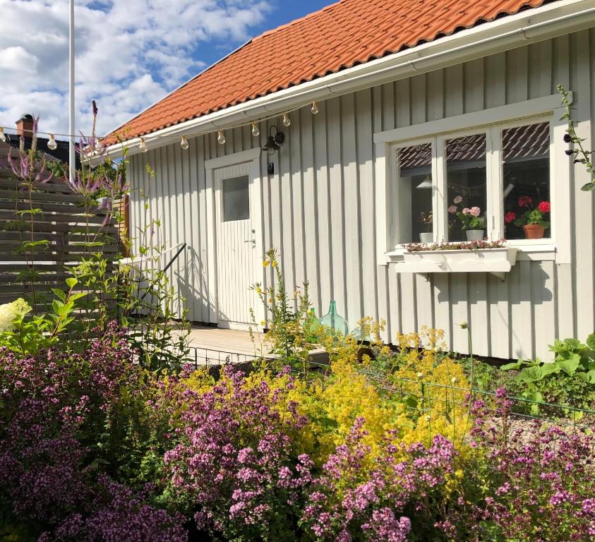 una pequeña casa con un jardín de flores delante de ella en Hatty's Guesthouse, en Motala