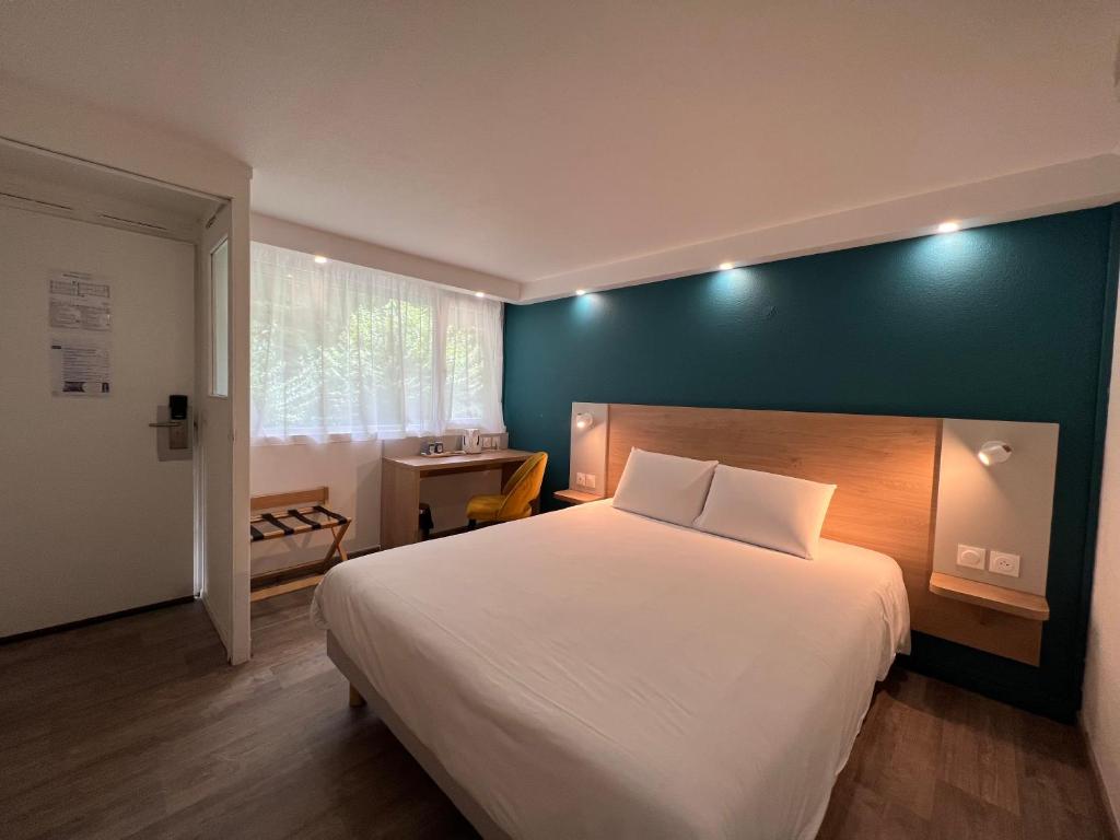 スダンにあるKyriad SEDANの緑の壁のベッドルーム1室(大きな白いベッド1台付)