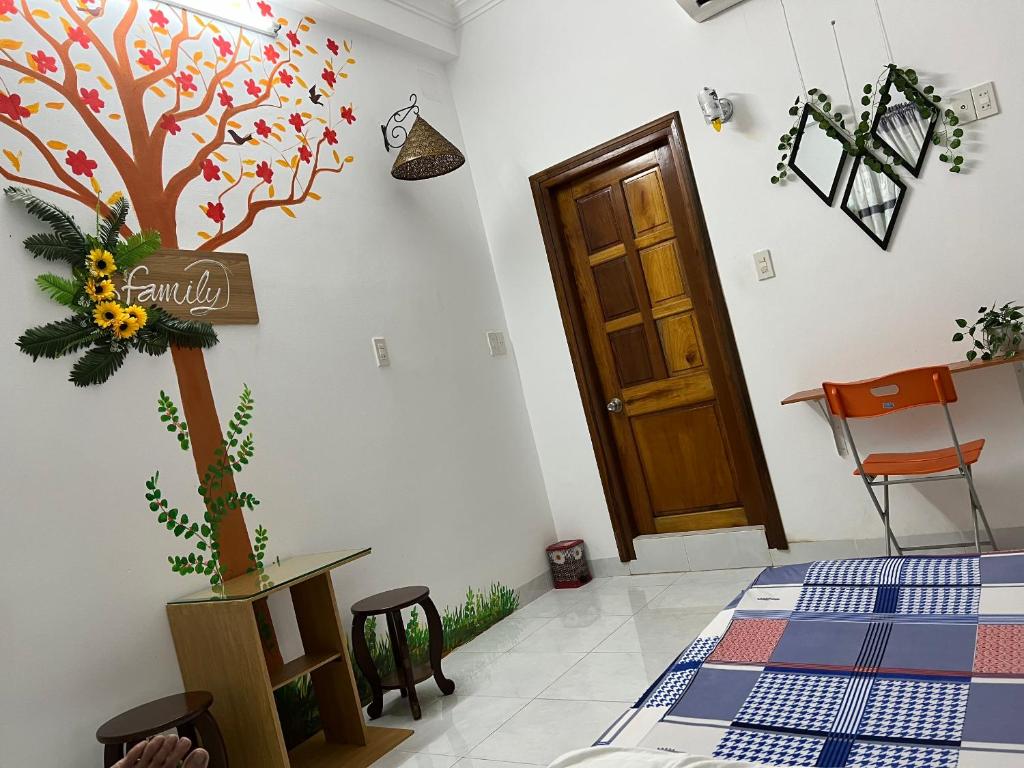 Habitación con un árbol pintado en la pared en Lotus homestay en Tuy Hoa