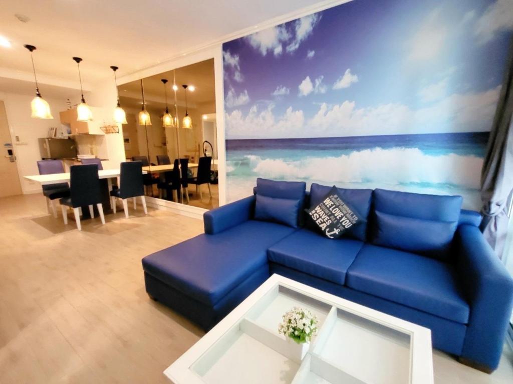 a living room with a blue couch and a table at My resort by Sea room in Hua Hin