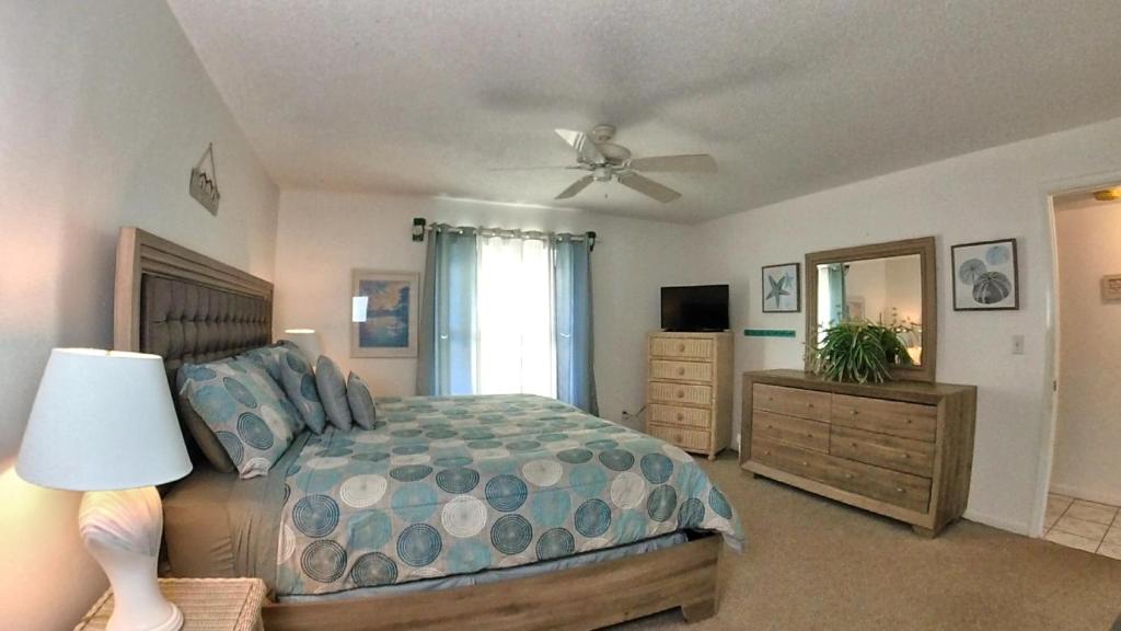 a bedroom with a bed and a ceiling fan at Sea Club Condo #12 in Clearwater Beach