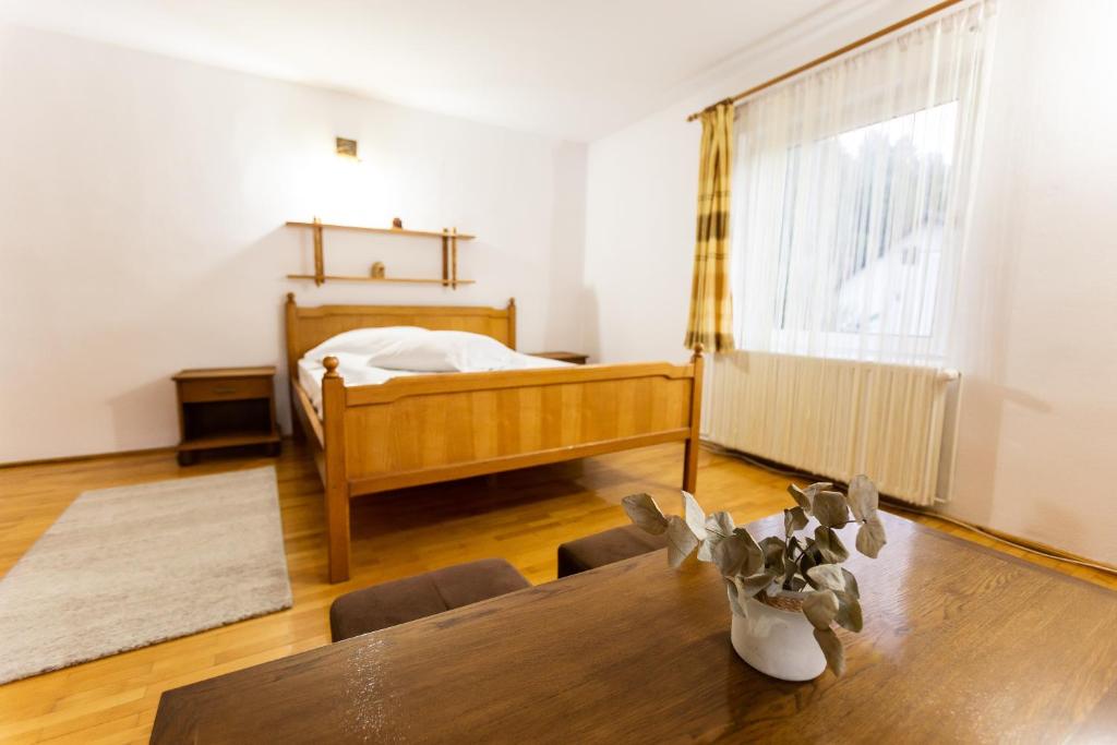 a bedroom with a bed and a wooden table with a dining room at Pensiunea Ionela in Moieciu de Jos