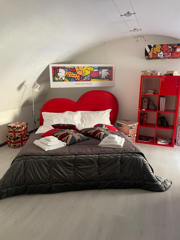 - une chambre avec un grand lit et une tête de lit rouge dans l'établissement Loft P&G, à Enna