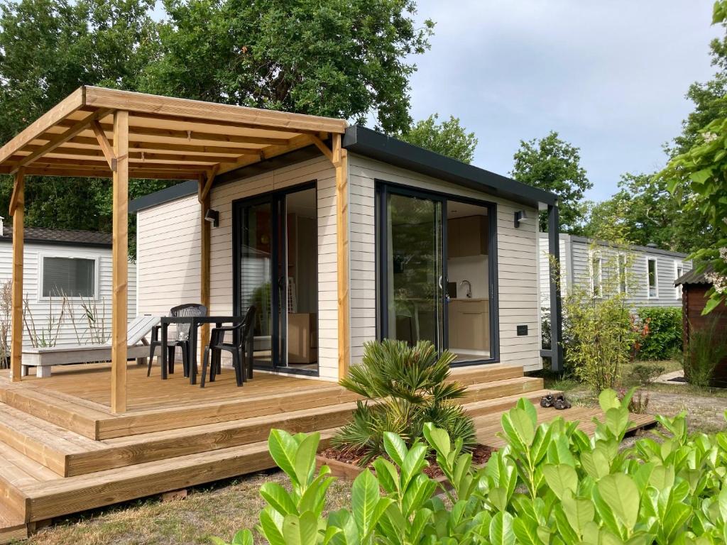 a tiny house with a deck and a gazebo at Cottage 2 pers KEY WEST Premium in Hourtin