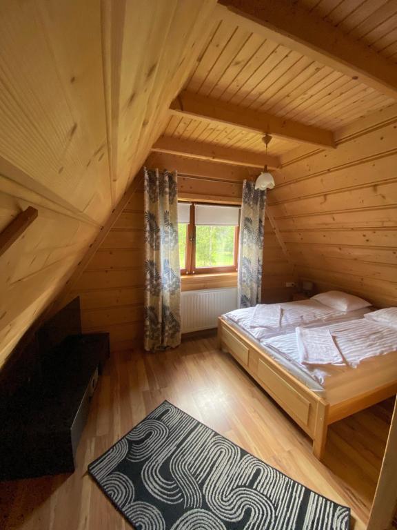 a bedroom with a bed in a wooden attic at Noclegi 25 H in Zakopane