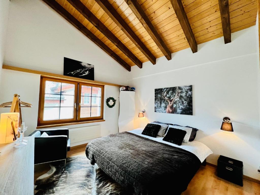 a bedroom with a large bed and a wooden ceiling at Saas-Fee renovated flat in center of the village in Saas-Fee