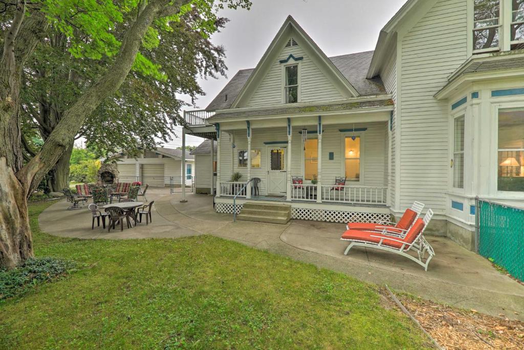 a house with a red chair on a patio at Coastal Grand - Walk to Lake Michigan! in Ludington