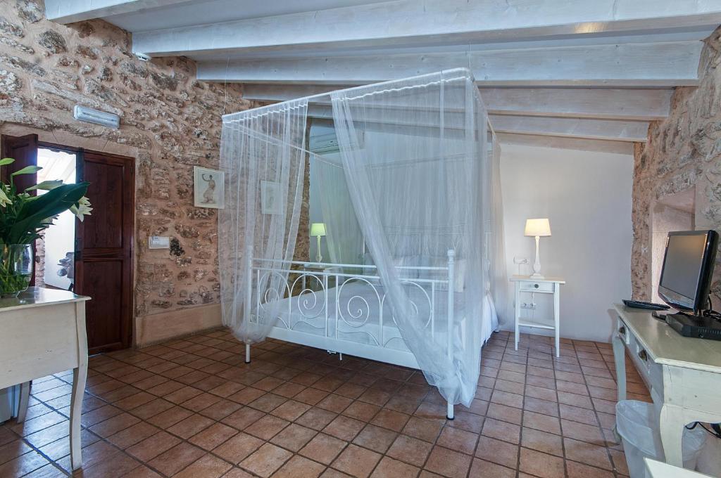 a bedroom with a bed with a mosquito net at Ca´n Pere in Alcudia