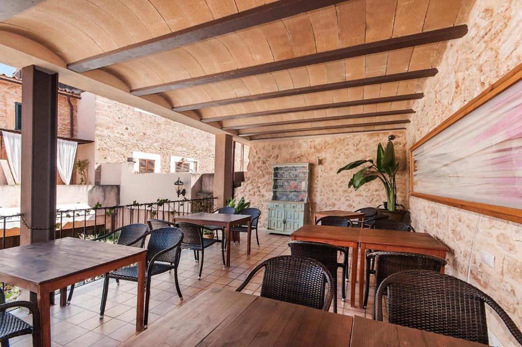 a restaurant with tables and chairs and a brick wall at Ca´n Pere in Alcudia