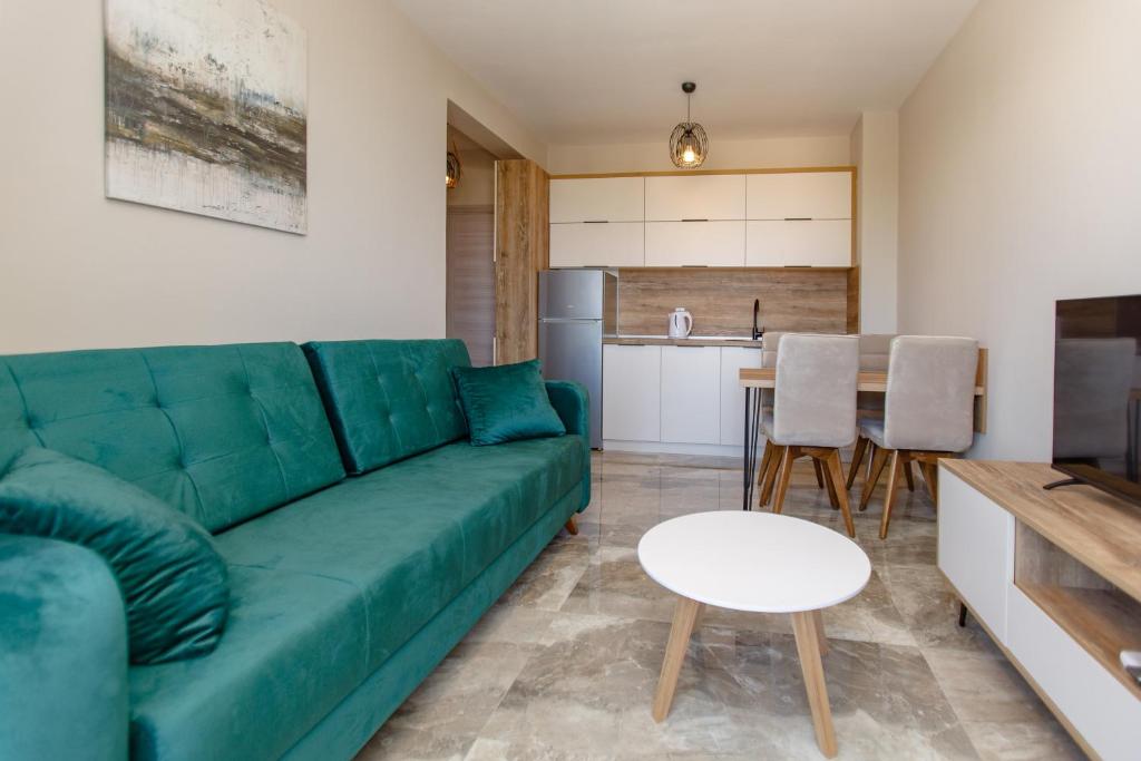屋吉耶塔的住宿－Posejdon Lux，一间带绿色沙发的客厅和一间厨房