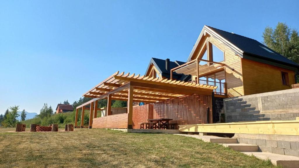 ein großes Holzhaus mit einer großen Veranda in der Unterkunft Cortina resort in Ivanjica