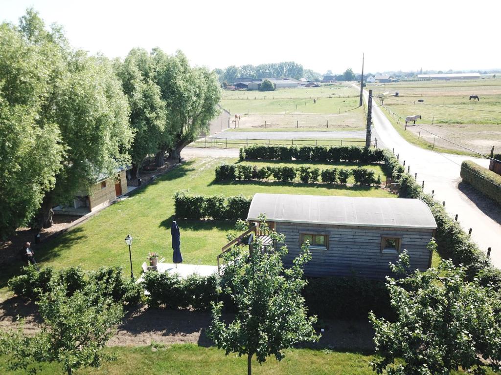 eine Luftansicht auf einen Garten mit einem Gebäude in der Unterkunft Camping des Saules in Jurbise