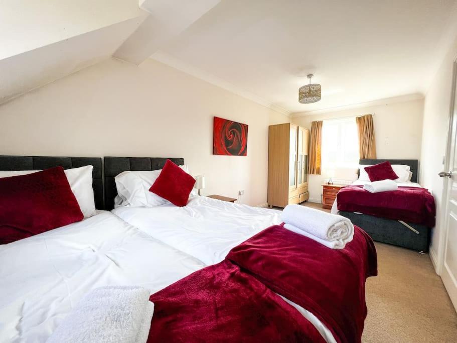 una camera con due letti con lenzuola rosse e bianche di 4 Bedroom house for Contractors,family,free parking,study,internet in ipswich a Ipswich