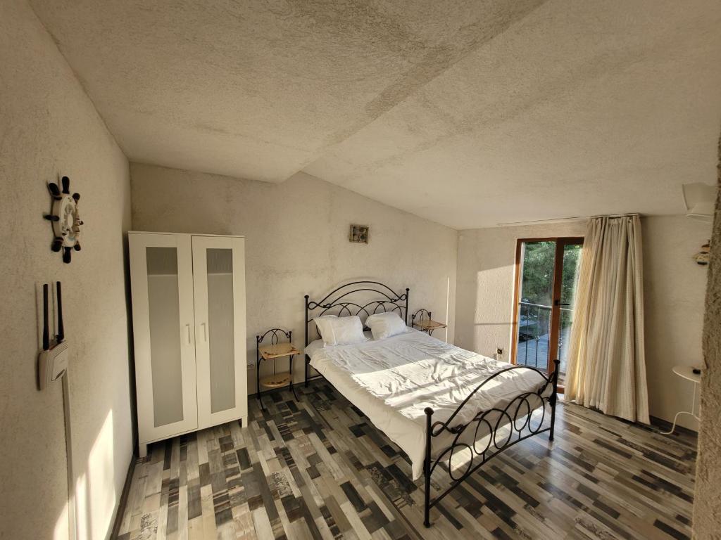 ein Schlafzimmer mit einem Bett und einem großen Fenster in der Unterkunft Vila Kalypso in Schitul