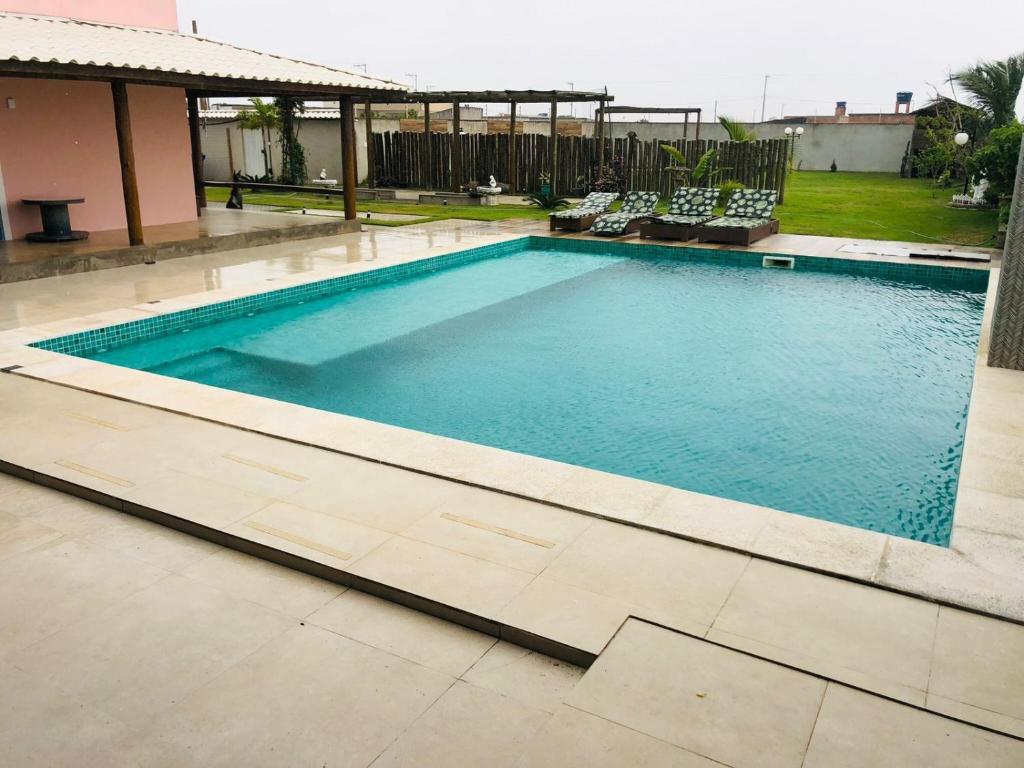 una gran piscina con sillas alrededor en Casa 4 quartos 2 Lofts Piscina en Marataizes
