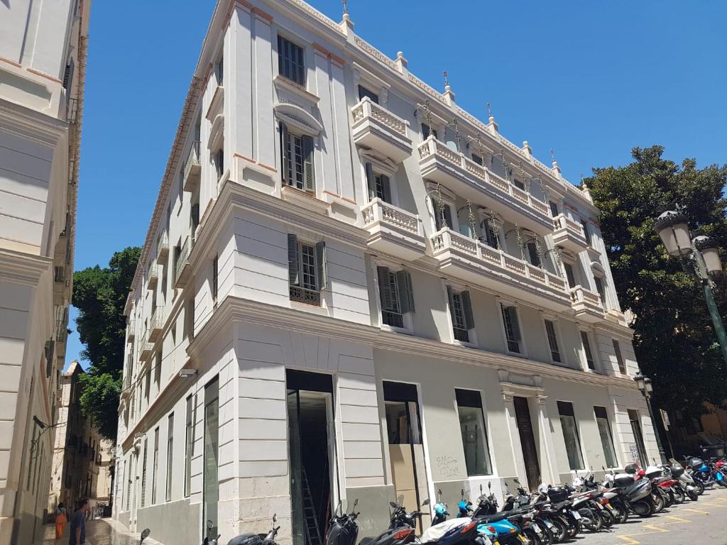 a white building with motorcycles parked in front of it at Apartamento Plaza del Teatro Parking free in Málaga