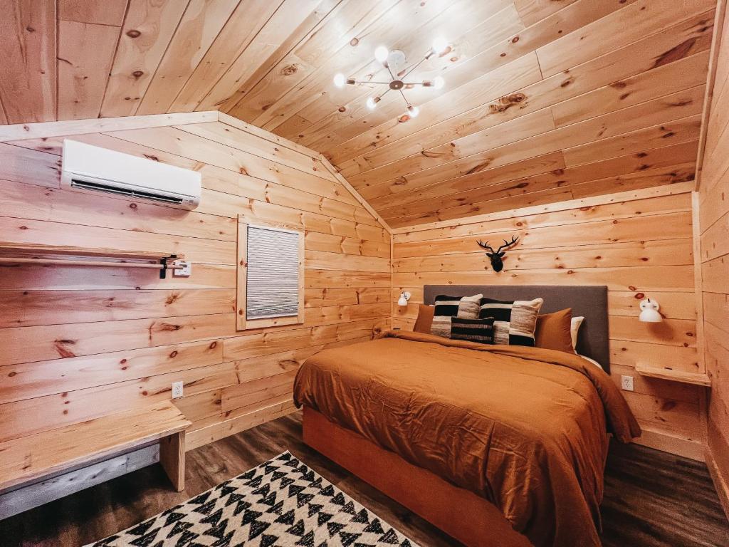 a bedroom with a bed in a wooden cabin at Cabin #9 One Bedroom W Kitchenette in Hartwell