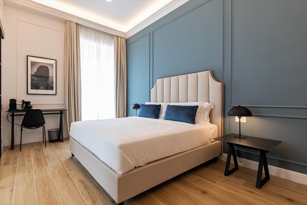 una camera da letto con un letto con pareti blu e un tavolo di Unico Relais a Napoli