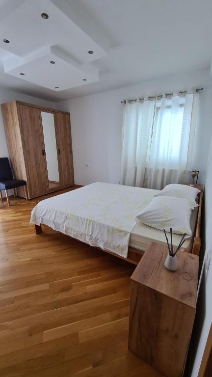 a bedroom with a large bed and a wooden table at Apartman Marija in Korčula