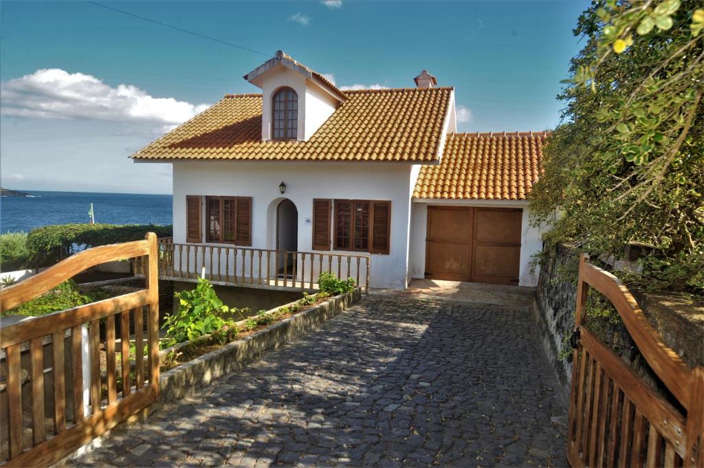 een klein wit huis met een hek en een hek bij Casa da Salga in Angra do Heroísmo