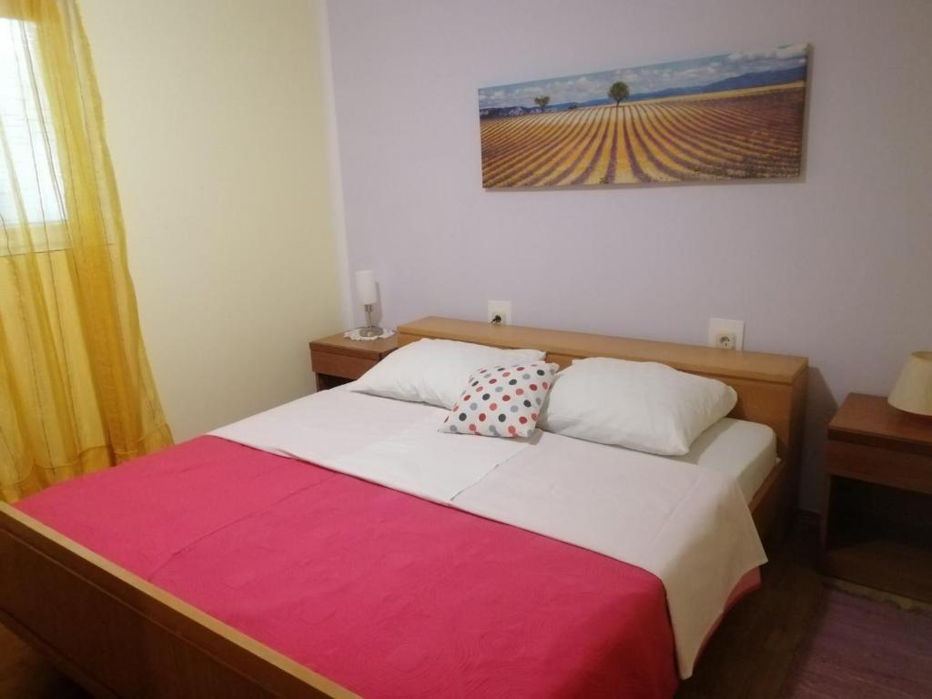 a bedroom with a bed with a red and white blanket at Kuća Melita -jacuzzi in Kastav