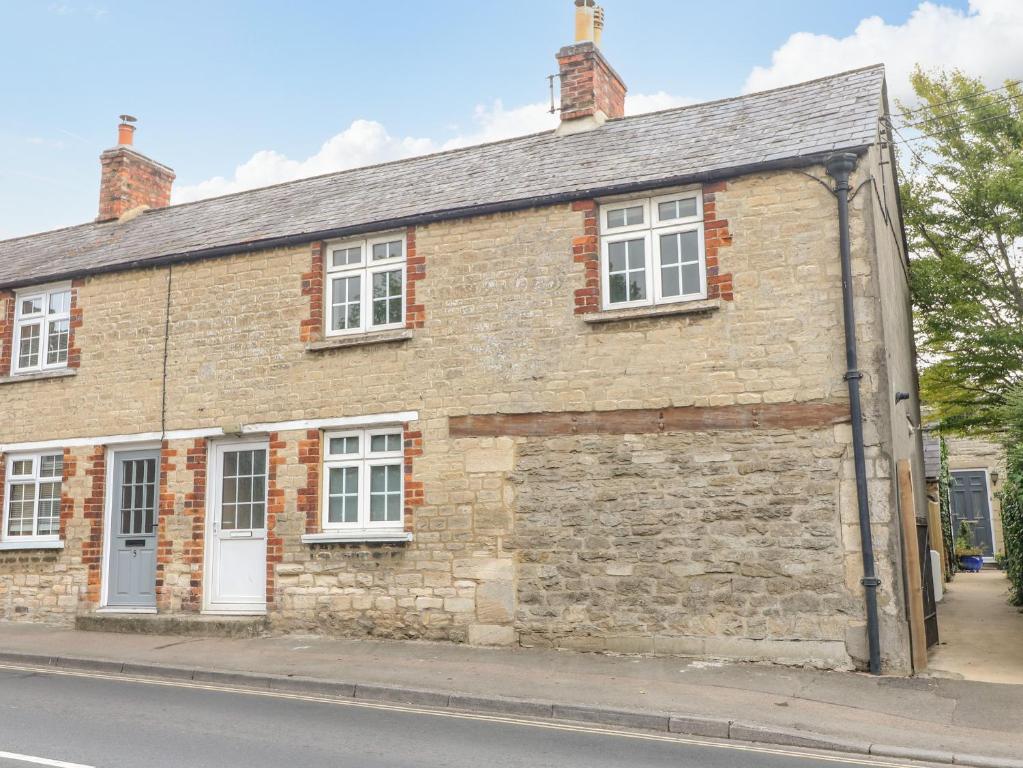 an old brick building on the side of a street at Halfpenny Cottage in Lechlade