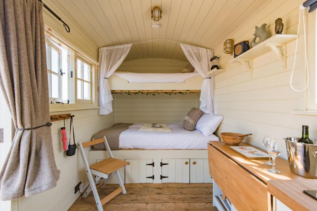 een kleine slaapkamer met een bed in een tiny house bij The Romney by Bloom Stays in Ashford