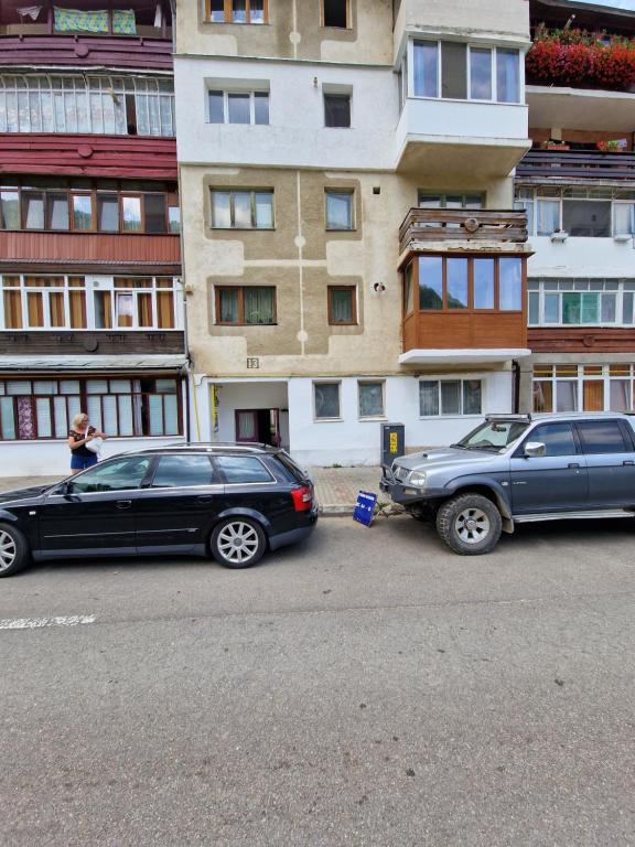 two cars parked next to each other on a city street at Apartment Slanic moldova in Slănic-Moldova
