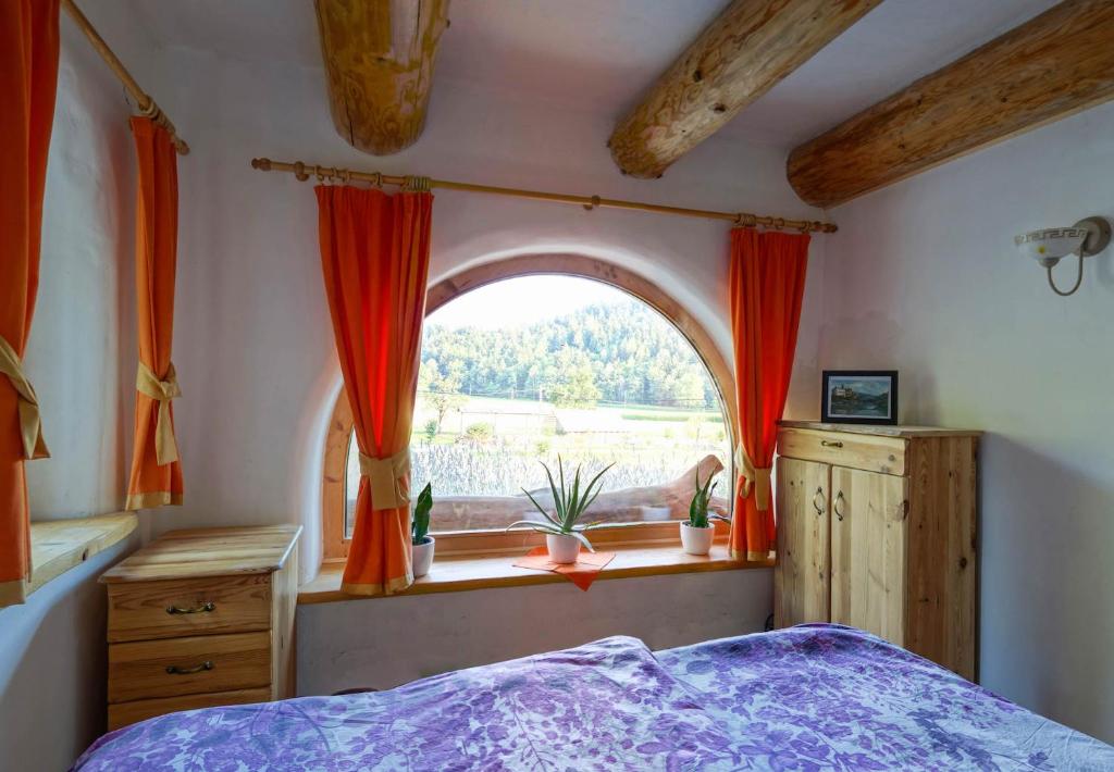 a bedroom with a large window with red curtains at Natur apartma Rudi in Begunje na Gorenjskem