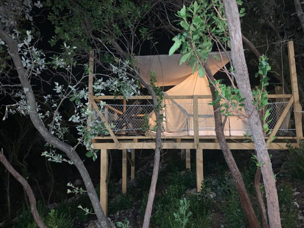 a bed in a tree house at night at Bigova Glamping in Kotor