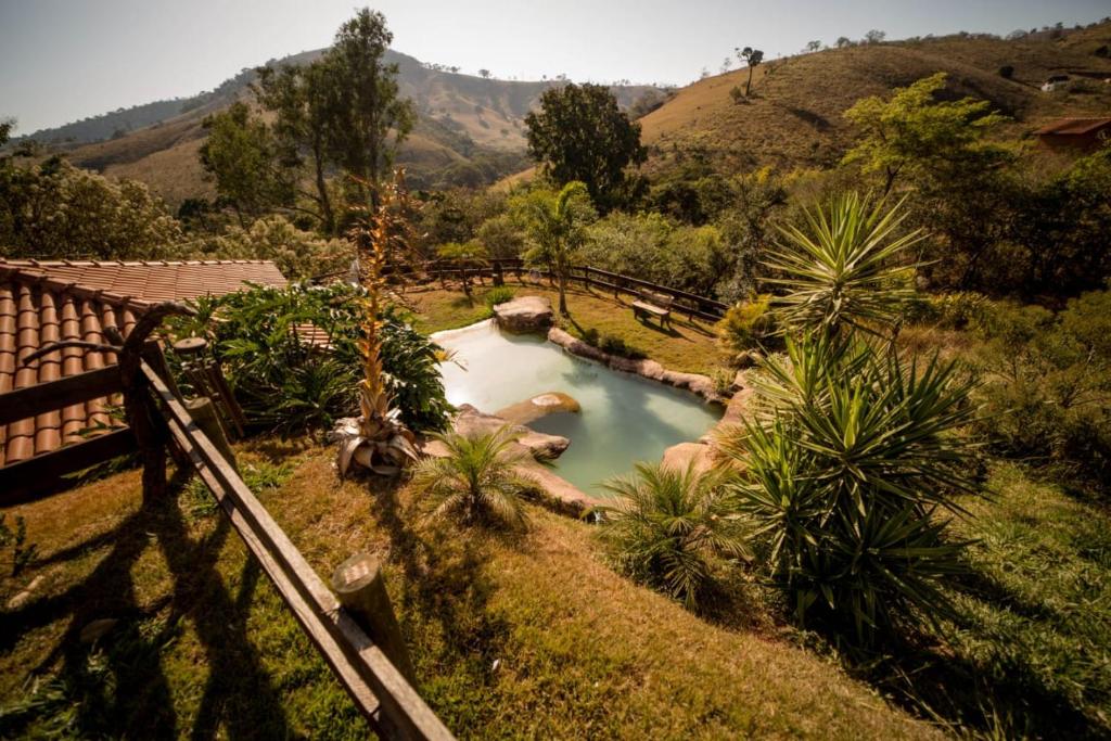 uma piscina no meio de um jardim em Casa de campo com piscina cascata artificial em São Lourenço
