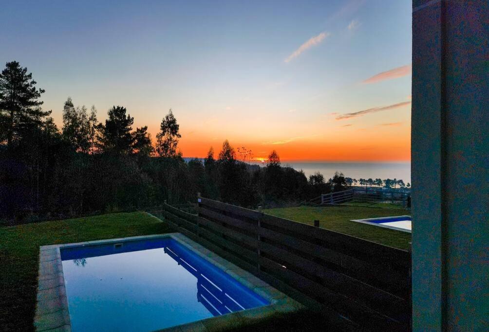 uma piscina com o pôr-do-sol ao fundo em CASA EN ALTAS CUMBRES DE PINGUERAL em Concepción