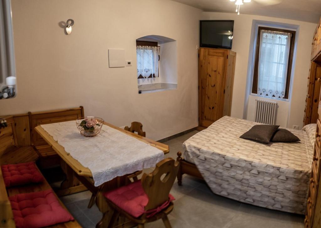 Residenza Cotruta Spiazzo في سبياتزو: غرفة معيشة مع طاولة وسرير