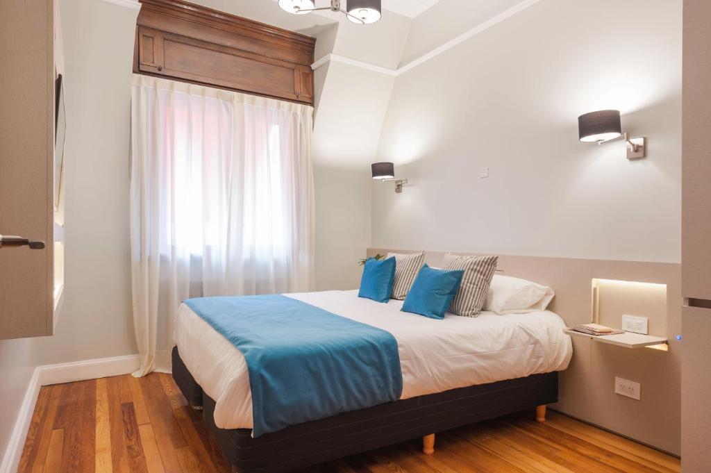 - une chambre avec un lit doté d'oreillers bleus et d'une fenêtre dans l'établissement Sarmiento Flats, à Buenos Aires