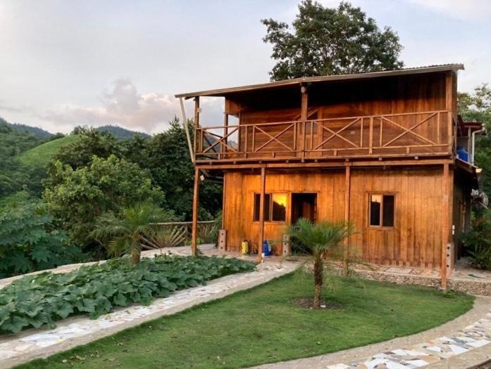 una casa de madera con un jardín delante de ella en Diosa de la Montaña, en Jama