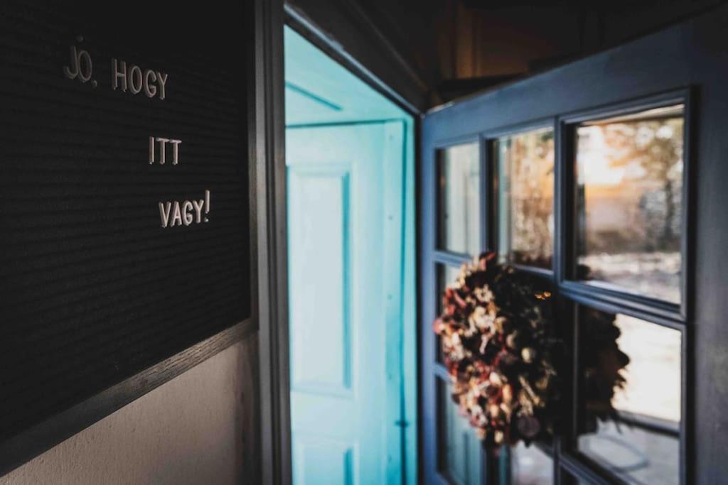 a door with a wreath next to a window at Kiskovász Pajta & Inn in Nagytevel