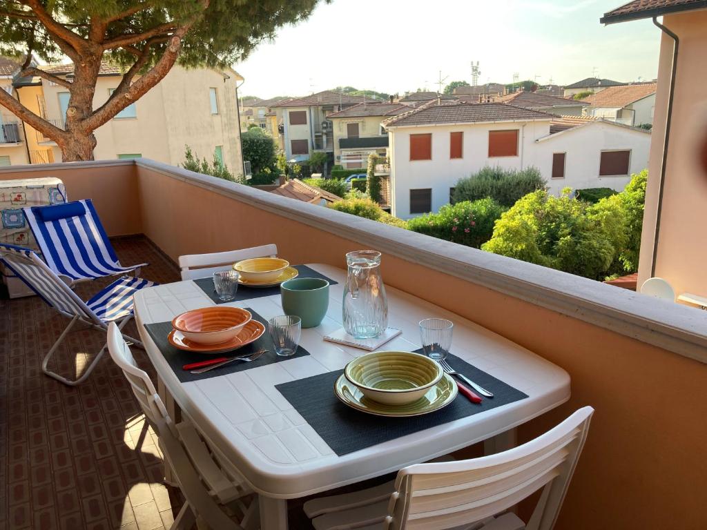 a table with plates and utensils on a balcony at Casa Selia in Cecina