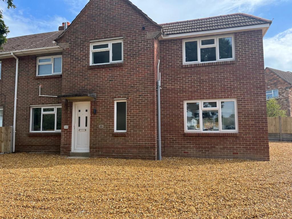 a red brick house with a white door at Stunning modern 6-Bedroom house all with en-suite in Poole