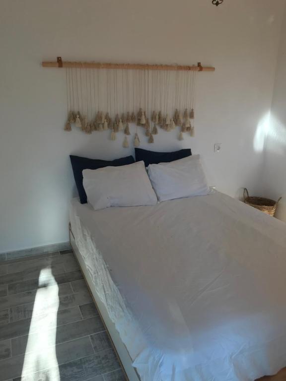 a bedroom with a large white bed in a room at Irini’s Attic in Nea Iraklia