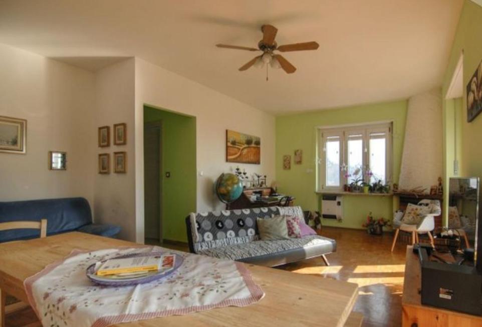 a living room with a couch and a ceiling fan at TORRE PELLICE Alloggio incantevole con parcheggio privato in Torre Pellice