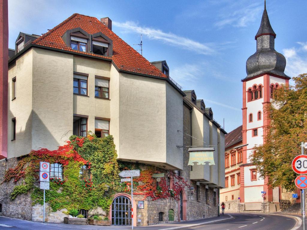 ein Gebäude mit einem Turm an der Seite einer Straße in der Unterkunft Hotel Grüner Baum in Würzburg