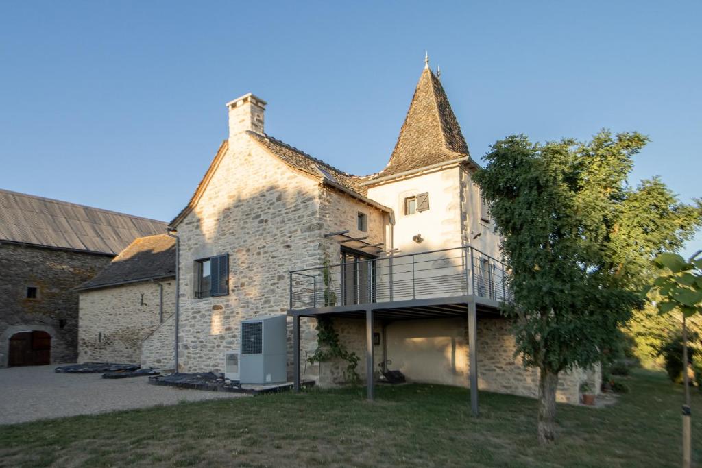 an external view of a large stone building with a balcony at La Maison de Louise in Colombiès