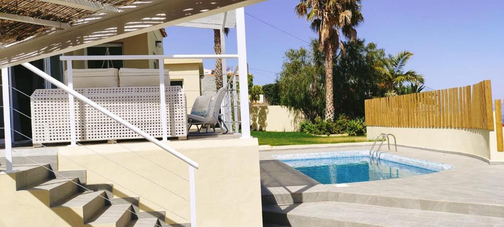 a swimming pool with stairs next to a house at Top Luxury Villa to the Ocean in Tablero