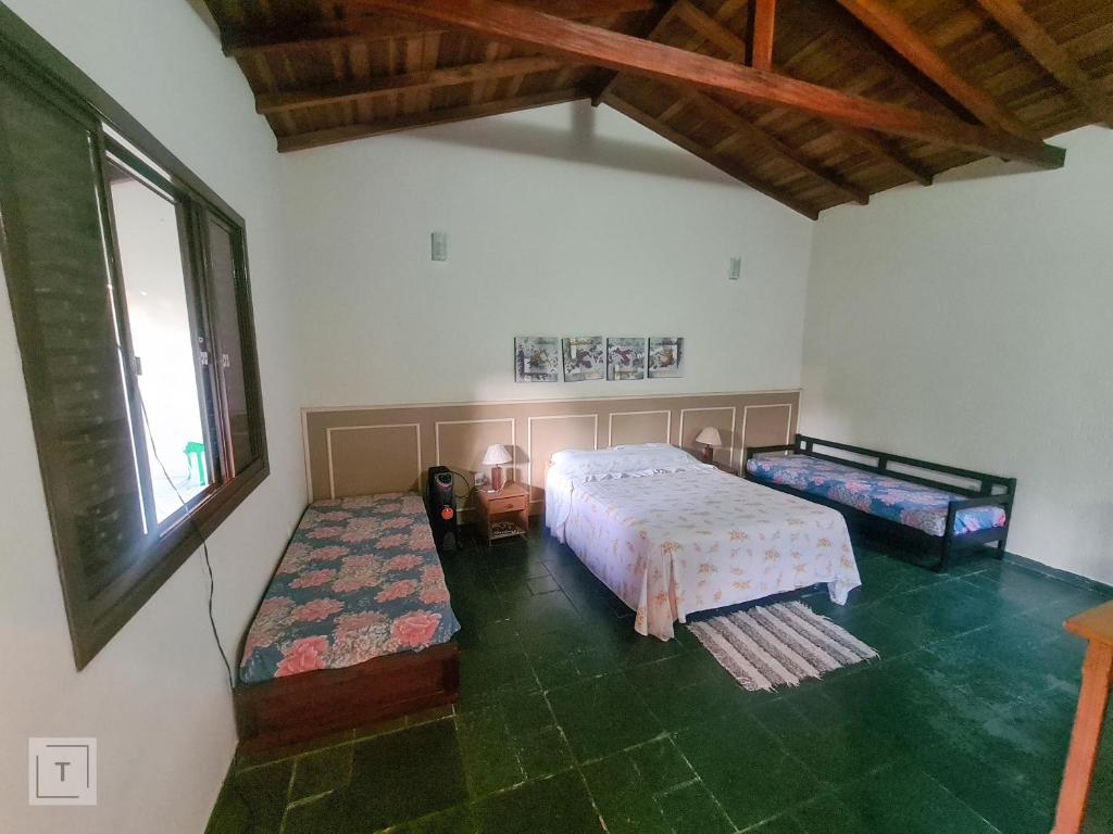 a bedroom with two beds and a window at Hospedaria do Ernesto in Itanhandu