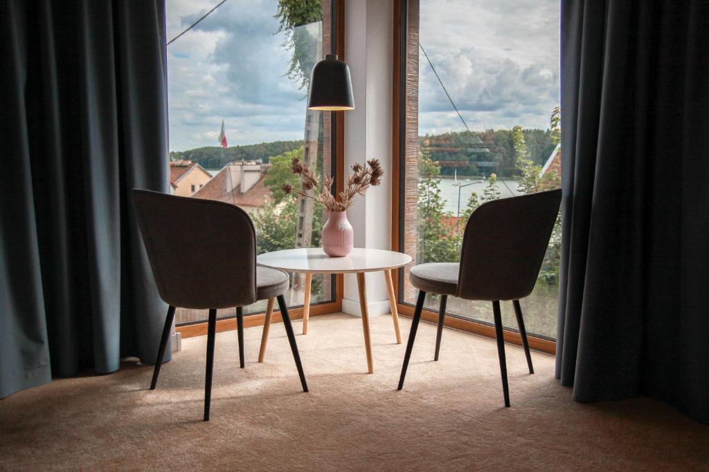stół i 2 krzesła w pokoju z oknem w obiekcie Apartament Ósemka w mieście Mikołajki