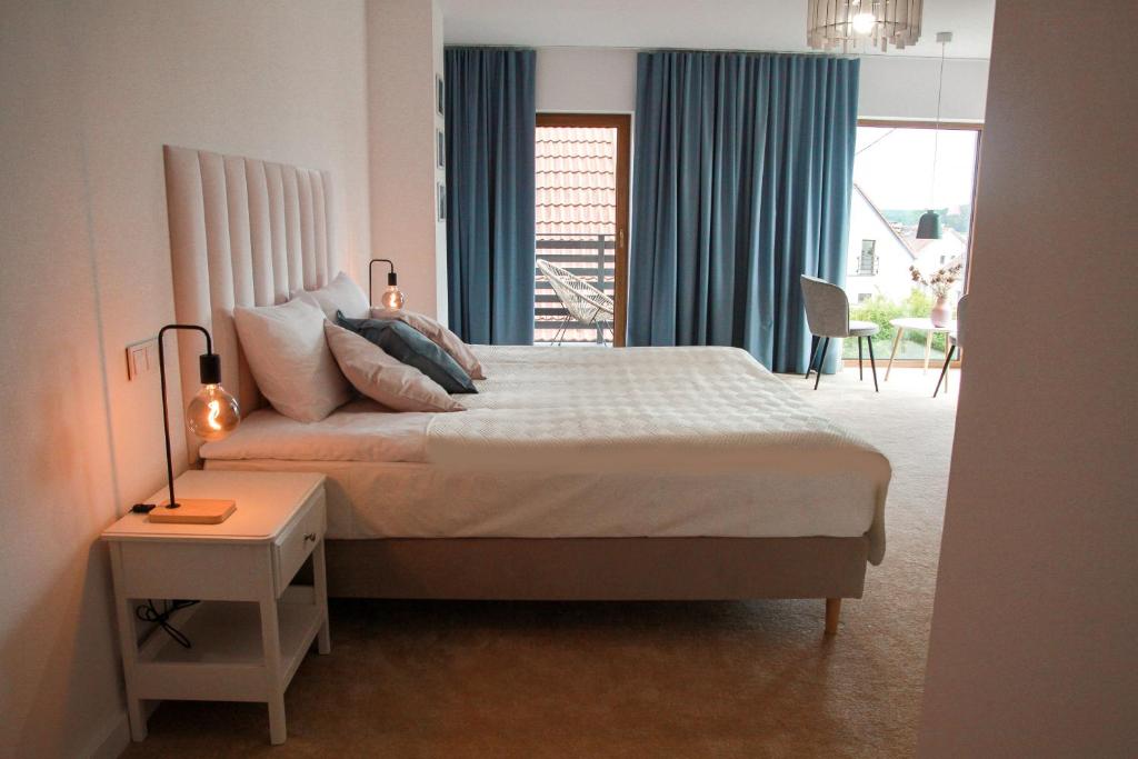1 dormitorio con cama, mesa y ventana en Apartament Ósemka en Mikołajki