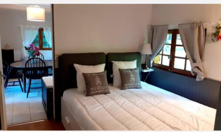 1 dormitorio con cama con almohadas y mesa en Ma Cabane Au Bord Du Lac en Neuvic
